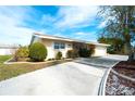 Single-story home with light-beige exterior, driveway and landscaping at 9820 Royal Palm Dr, Bradenton, FL 34210