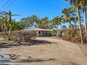 Single-story home with metal roof and spacious driveway at 1221 S Basin Ln, Sarasota, FL 34242