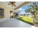 Covered patio with a ceiling fan and views of the lush yard and water at 12343 Lavender Loop, Bradenton, FL 34212
