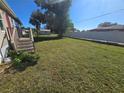 Large grassy backyard with a wooden fence at 3105 Sunrise Trl, Port Charlotte, FL 33952