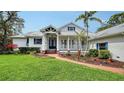 Charming home featuring a well-manicured lawn, brick path, and cozy front porch at 3930 Elysian Woods Ln, Sarasota, FL 34231