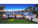 Beautiful home exterior with a lush lawn and inviting covered front porch at 3930 Elysian Woods Ln, Sarasota, FL 34231