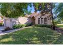 Tan house with lush landscaping and a walkway to the entrance at 7443 Riviera Cv, Lakewood Ranch, FL 34202