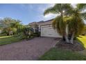 Single-Gathering home with palm trees, landscaping, and brick driveway at 12132 Gannett Pl, Lakewood Ranch, FL 34211