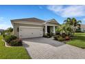 Beautiful home with a two-car garage, a paver driveway, and lush landscaping at 13789 Old Creek Ct, Parrish, FL 34219