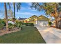 Attractive yellow house with a two-car garage and lush landscaping at 5101 Island Date St, Sarasota, FL 34232