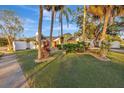 House exterior showcasing a large yard, mature trees, and a white fence at 5101 Island Date St, Sarasota, FL 34232