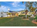 Well-maintained yellow house with a green lawn, a white fence, and a red front door at 5101 Island Date St, Sarasota, FL 34232