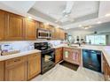 Well-equipped kitchen with wood cabinets, granite countertops, and modern appliances at 6609 Stone River Rd # 104, Bradenton, FL 34203