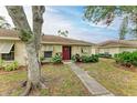 Exterior of a single-story home featuring a red door and walkway at 718 N Jefferson Ave # 718, Sarasota, FL 34237