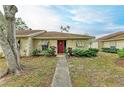 Front view of a single-story home with red door and walkway at 718 N Jefferson Ave # 718, Sarasota, FL 34237