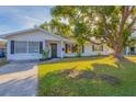 Inviting white brick home with mature trees and a well-maintained lawn at 911 42Nd W St, Bradenton, FL 34205