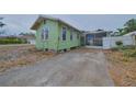 Light green single-story home with a screened porch and driveway at 2028 30Th E Ave, Bradenton, FL 34208