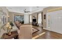 The well-lit living room offers comfortable furniture, wood floors, and views of the backyard at 2520 Terracina Dr, Venice, FL 34292