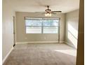 Bright living area with large windows, plush carpeting, and a ceiling fan at 2766 Heather Pl, Sarasota, FL 34235