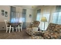 Cozy living room with two recliners, a dining table, and large windows at 3333 26Th E Ave # 1107, Bradenton, FL 34208