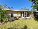 Rear exterior view of a single-story home with screened porch, landscaping, and green lawn at 4339 Bowling Green Cir # 19, Sarasota, FL 34233