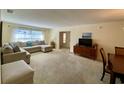 Living room with carpeted floors, a sectional sofa, and a view into another room at 4339 Bowling Green Cir # 19, Sarasota, FL 34233