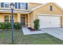 Close-up view of the home's entrance, landscaping, and attached garage at 7005 57Th E Ter, Palmetto, FL 34221