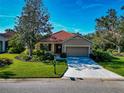 One-story house with tile roof, lush landscaping, and a driveway at 734 Foggy Morn Ln, Bradenton, FL 34212