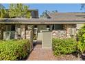 Welcoming front entry with a stone and wood design and lush greenery at 1501 Peregrine Point Dr, Sarasota, FL 34231