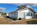 Side view of a single-story home with light blue siding and white trim at 214 Genet Ct, Sun City Center, FL 33573