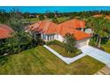 Single-story home with tile roof, lush landscaping, and a two-car garage at 616 Misty Pond Ct, Bradenton, FL 34212