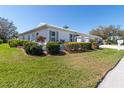 Charming single-story home featuring a well-manicured lawn and colorful landscaping at 6913 8Th W Ave, Bradenton, FL 34209