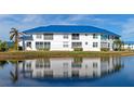 White two-story building with a blue metal roof, balconies, and waterfront views at 901 Sandpiper Cir # 901, Bradenton, FL 34209