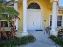 Welcoming front porch area with white double doors, columns, and tropical landscaping at 779 Nectar Rd, Venice, FL 34293