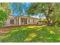 Landscaped backyard with large tree and screened patio at 108 Corte Del Rosa, Venice, FL 34285