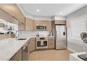 Modern kitchen with stainless steel appliances, white countertops, and ample cabinet space at 109 Woodland Pl, Osprey, FL 34229