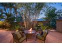 Outdoor patio area with a fire pit, cozy seating, and lush tropical plants at 1656 Hillview St, Sarasota, FL 34239