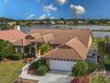 Charming home with tile roof, attached garage, and lush landscaping at 4875 Wood Pointe Way, Sarasota, FL 34233