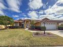 Inviting front yard with lush green grass, mature trees, and a welcoming walkway at 4875 Wood Pointe Way, Sarasota, FL 34233