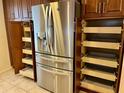 Stainless steel refrigerator with surrounding wooden cabinets, including pull-out shelving, maximizing kitchen storage at 5405 Fair Oaks St # 5405, Bradenton, FL 34203