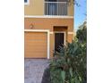 Front entry with attached garage and tropical landscaping at 5467 Soapstone Pl # 203, Sarasota, FL 34233