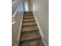 Carpeted staircase to the upper level at 5467 Soapstone Pl # 203, Sarasota, FL 34233