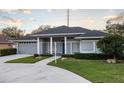 Gray house with blue door, columned porch, and landscaped yard at 566 Oak Bay Dr, Osprey, FL 34229