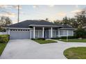 Gray house with blue door, columned porch, and landscaped yard at 566 Oak Bay Dr, Osprey, FL 34229