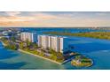 Panoramic aerial view of waterfront condo buildings, private island, and calm bay waters at 9393 Midnight Pass Rd # 201, Sarasota, FL 34242