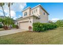 Side view of a two-story home with a two-car garage and manicured shrubs at 12342 Lavender Loop, Bradenton, FL 34212
