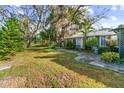 Spacious backyard with a large grassy area, mature trees, and a patio at 1285 & 1289 Hagle Park Rd, Bradenton, FL 34212
