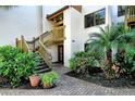 Ground level entrance with stairs and lush landscaping at 1700 Cove Ii Pl # 311, Sarasota, FL 34242