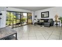 Living room with tiled floors, sectional sofa, and screened patio access at 1700 Cove Ii Pl # 311, Sarasota, FL 34242