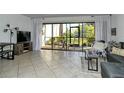 Living room with tiled floors, sectional sofa, and screened patio access at 1700 Cove Ii Pl # 311, Sarasota, FL 34242