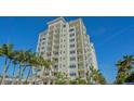 Coastal high-rise building surrounded by lush palm trees at 2050 Benjamin Franklin Dr # B603, Sarasota, FL 34236