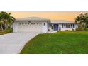 Single-story home at sunset with a welcoming front yard at 3325 Spring Mill Cir, Sarasota, FL 34239