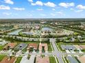 Aerial view of a house in a residential neighborhood with a pond nearby at 4905 Avila Lakes Dr, Wimauma, FL 33598