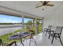 Relaxing screened porch with wicker table and chairs overlooking the water at 6029 E Peppertree Way # 116, Sarasota, FL 34242